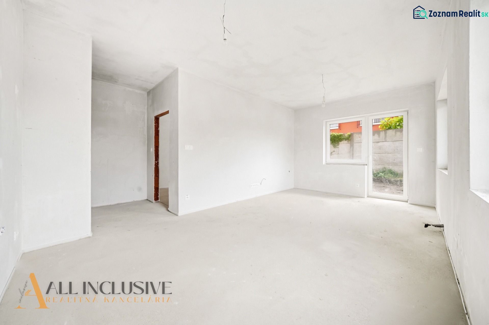 An empty room in a 3-bedroom apartment with a window and access to the terrace.