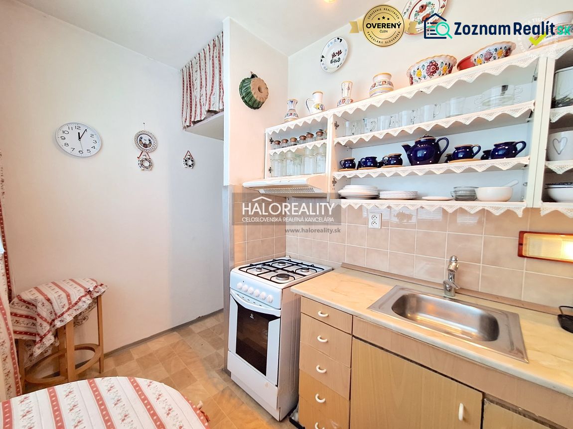 A kitchen in a 2-room apartment with a wooden decor and open shelves.