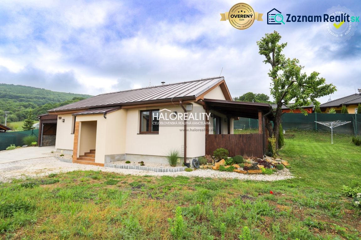 A family house in Dohňany with a lawn and a gazebo in the garden, with hills visible behind it.