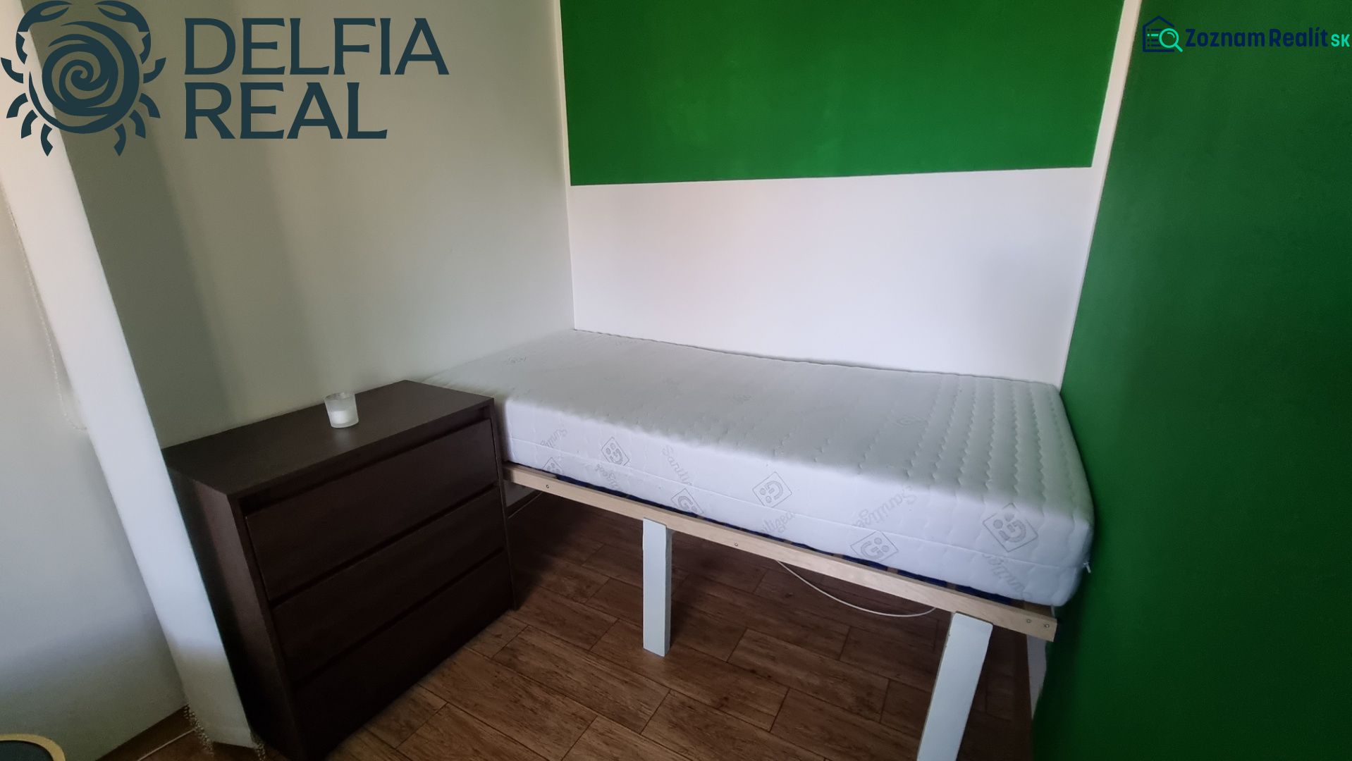 Simple furnishing of a studio apartment with a bed and a chest of drawers on a floor with a wooden decor.