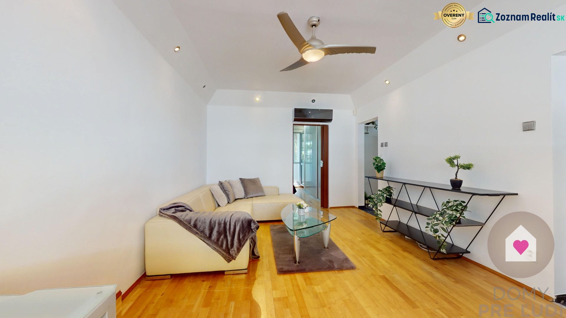 Living room with a cream sofa, glass table, and wooden decor flooring in a 4-room apartment.