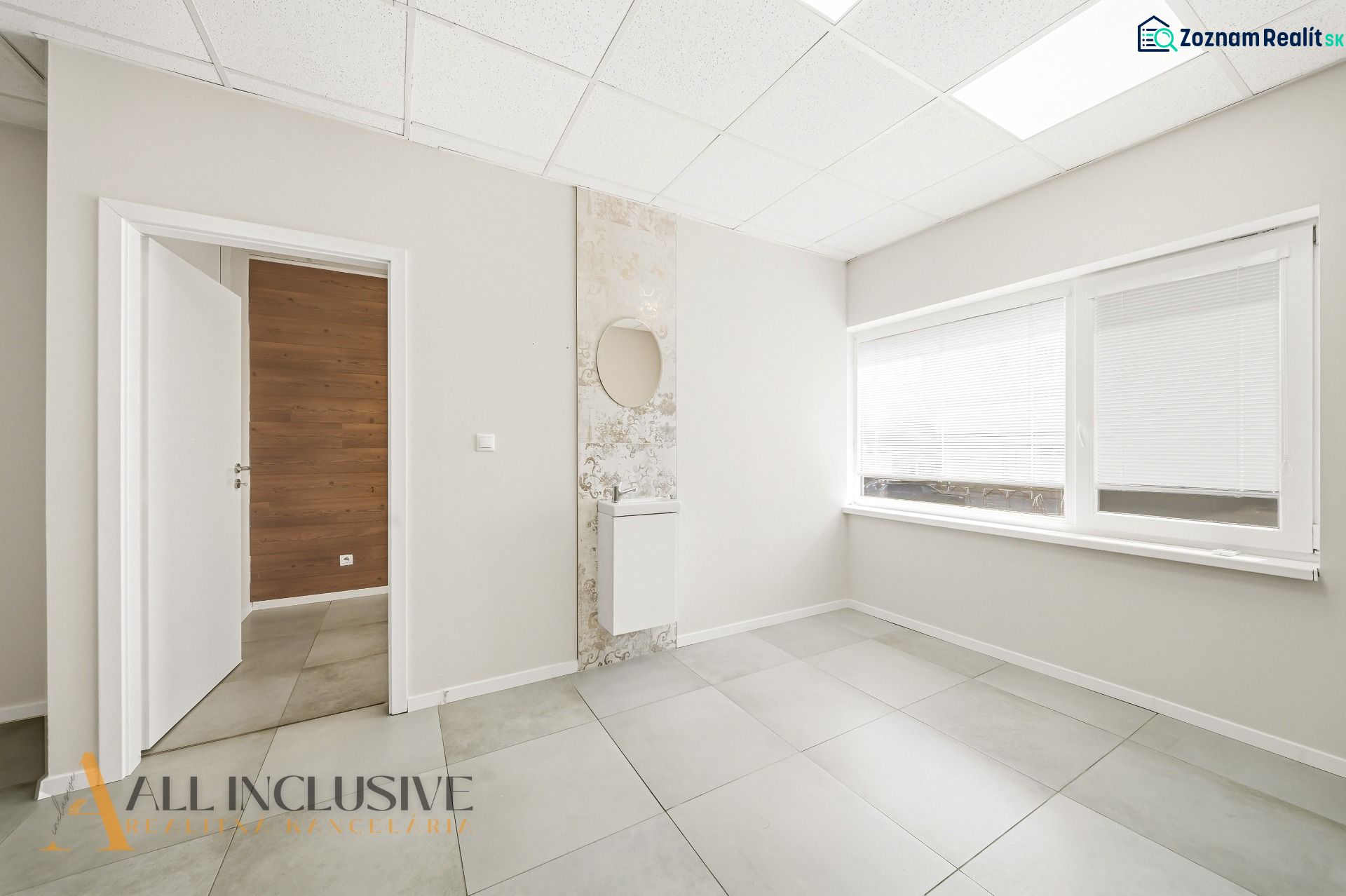 Interior of commercial spaces with white walls, tiles, and a large window.