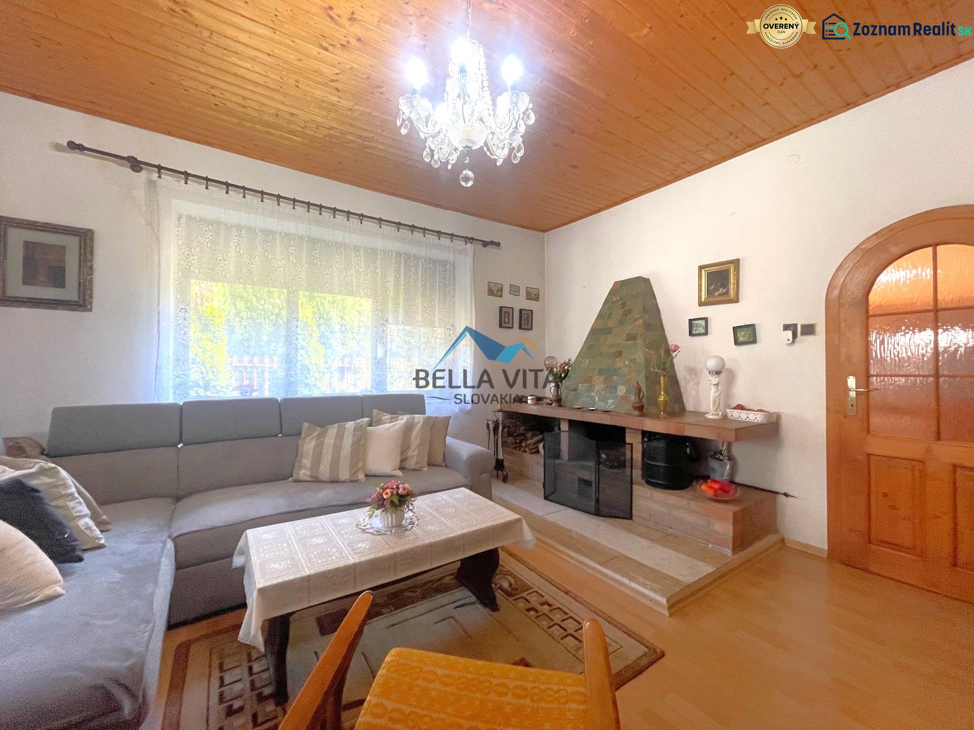 Obývacia izba v rodinnom dome s podlahou s dreveným dekorom a krbom.