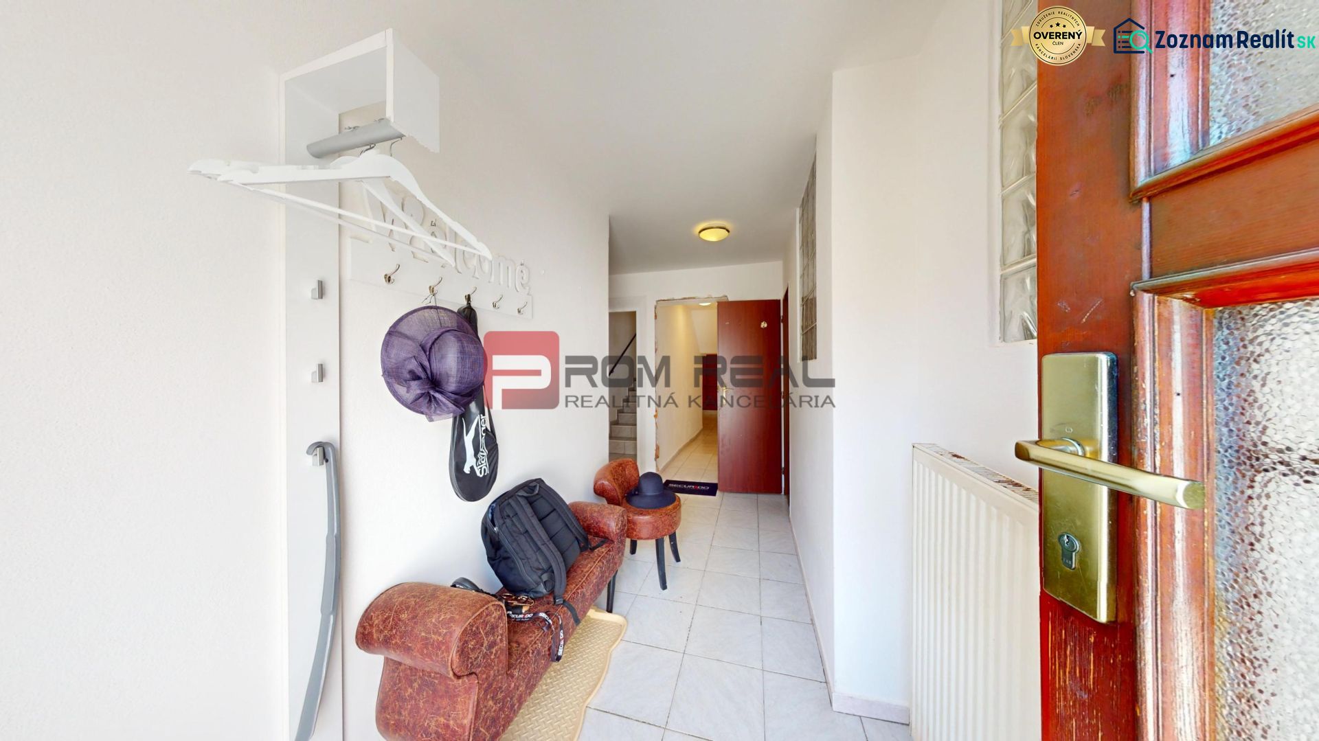 Entrance hallway in a family house with a coat rack and seating, tiled floor.