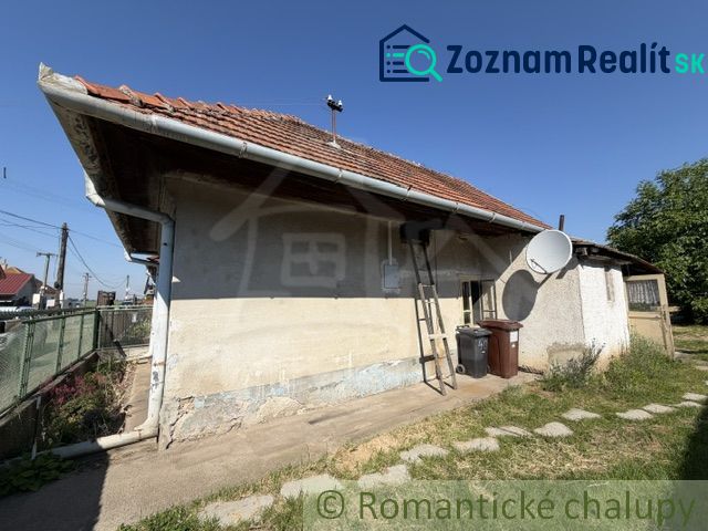 A family house in Šurany with a red roof and a satellite dish.