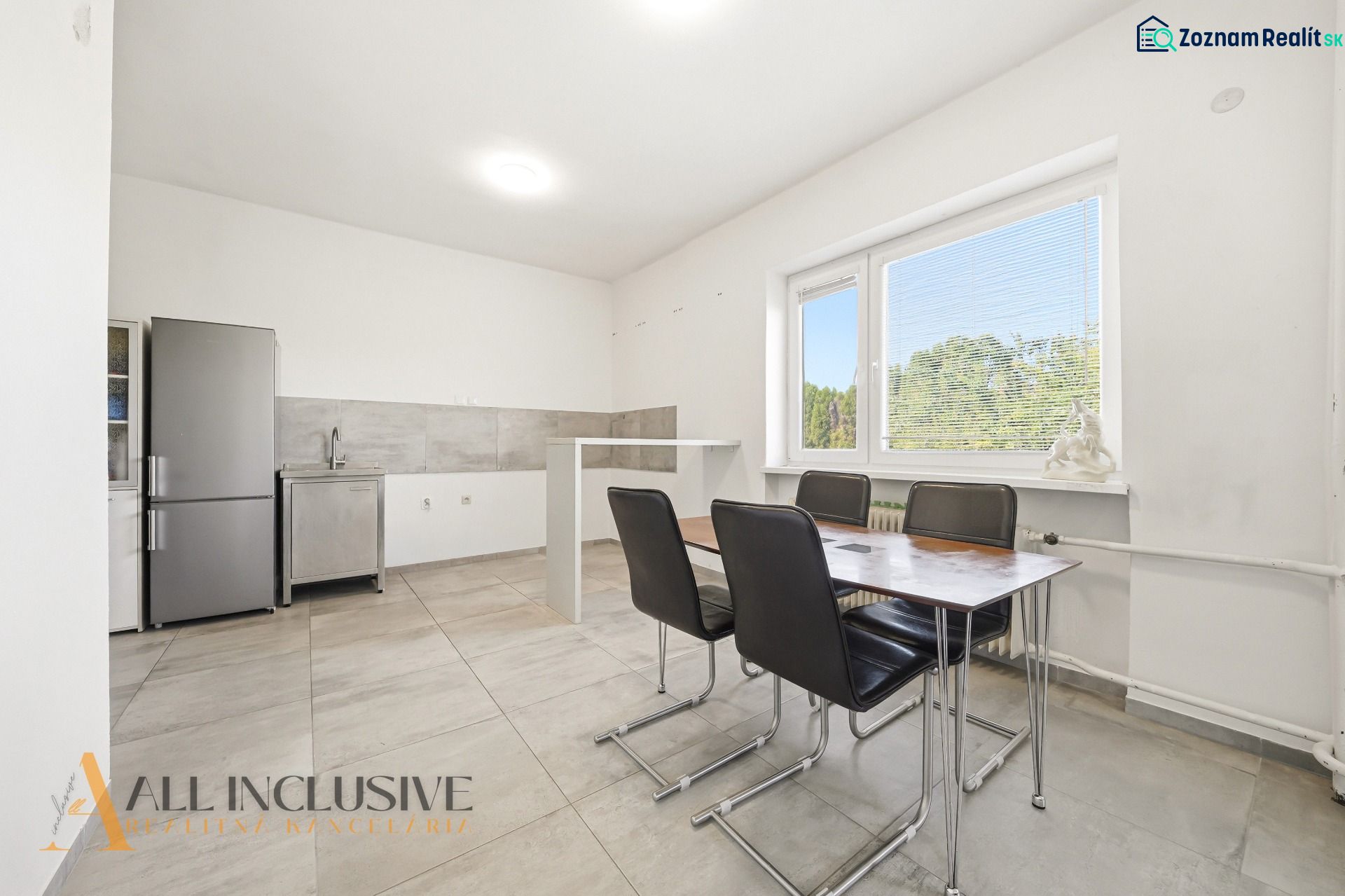 Dining room in a family house with a simple kitchen unit and a dining table.