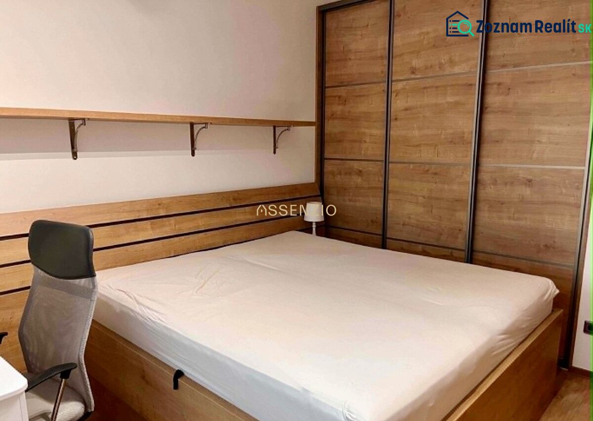 Bedroom in a 2-room apartment with a bed and a wardrobe, floor with wooden decor.