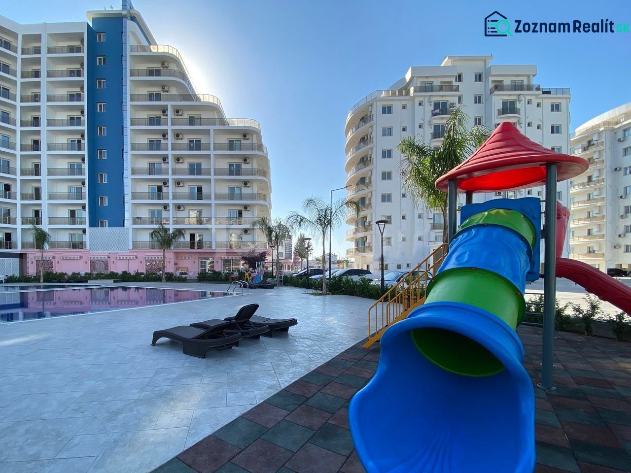 Playground and swimming pool near residential buildings in the city of Iskele.