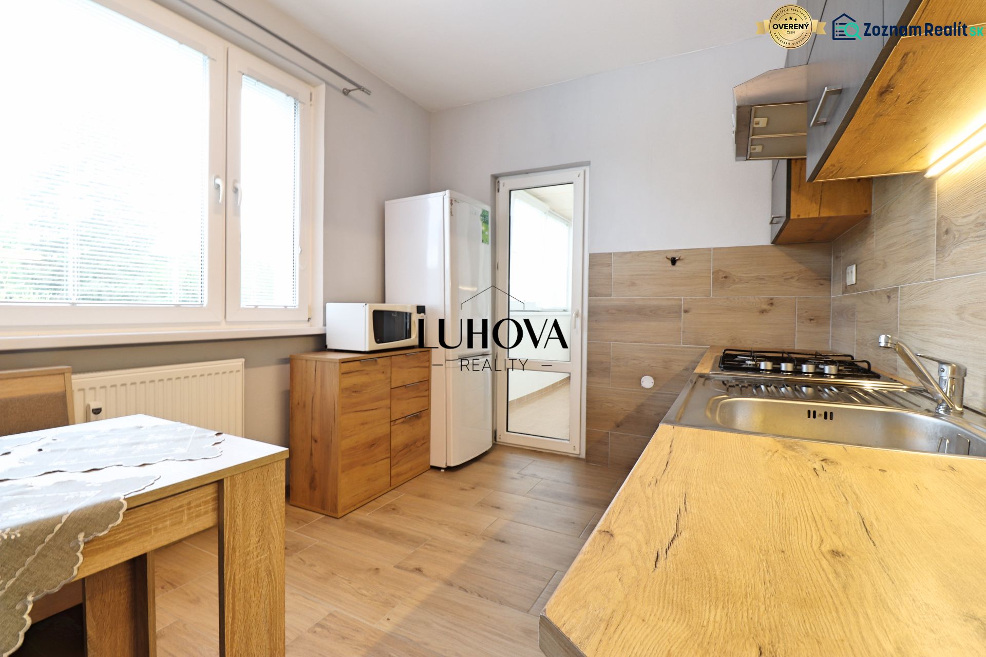 A kitchen in a 3-room apartment with a wooden floor decor and appliances.