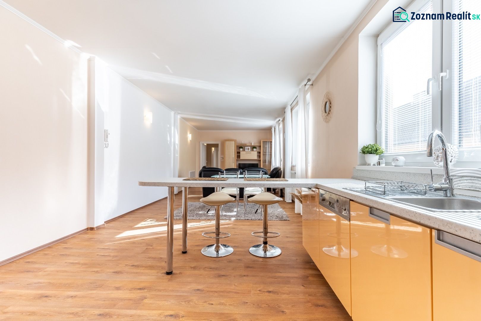 A kitchen in a 3-room apartment with an island and a floor with a wood decor.