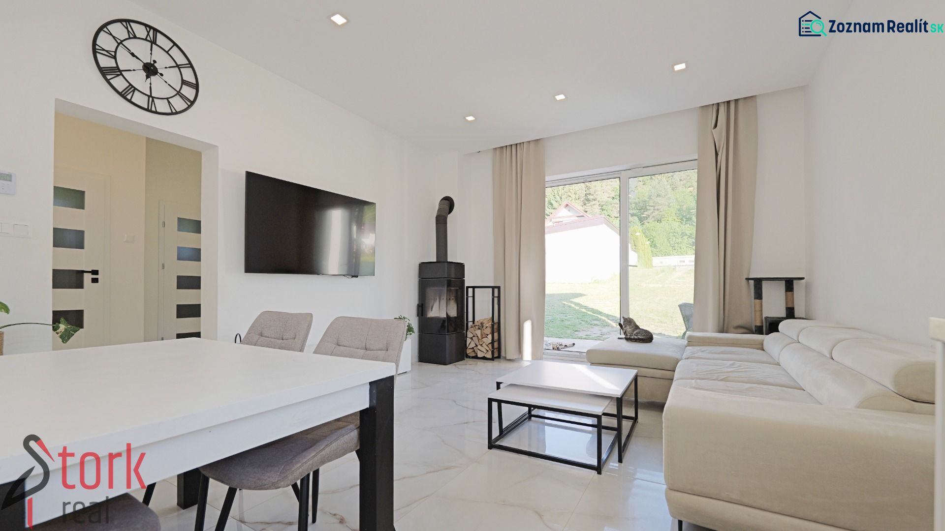 Living room in a family house with a television, fireplace, and large window.