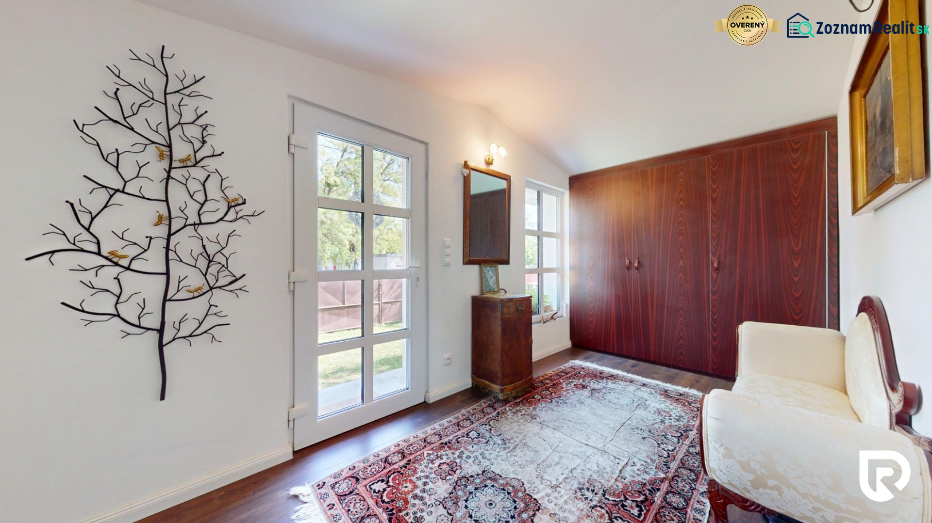 Interior of a family house with art on the wall, a carpet, and a wooden decor floor.