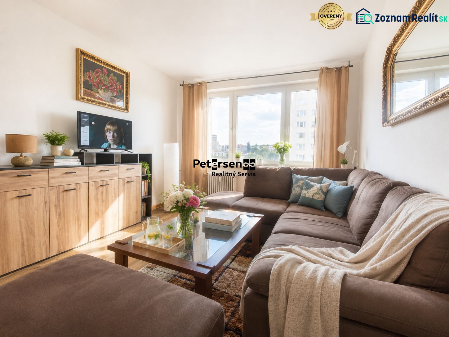 Living room in a 3-room apartment with a dark sofa and a large window.