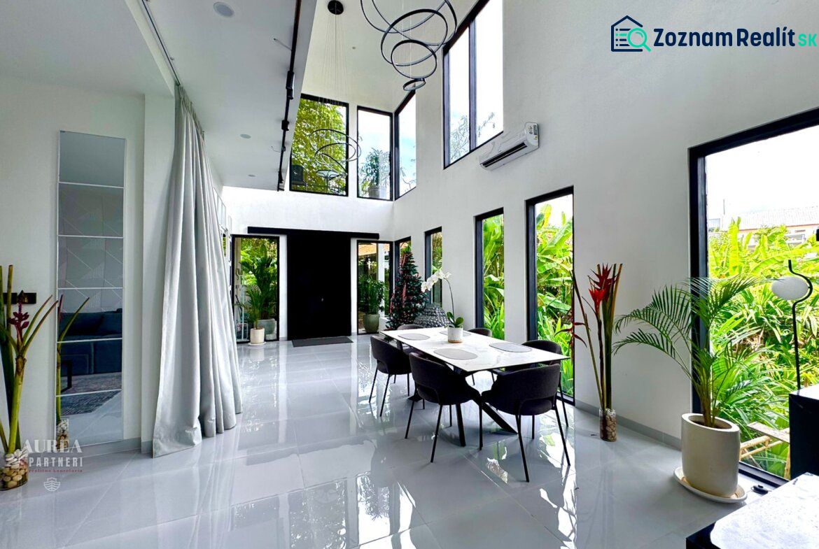 Spacious bright interior of a villa with large windows and modern furniture.
