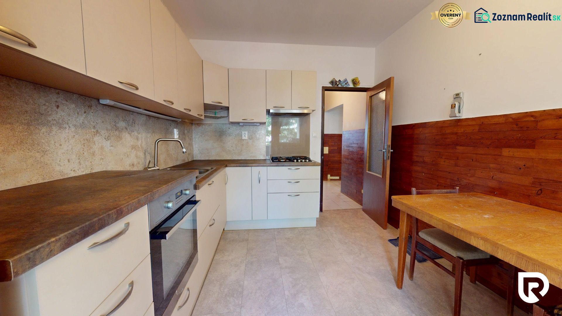 A kitchen in a 3-room apartment with a wooden decor and a corner countertop.