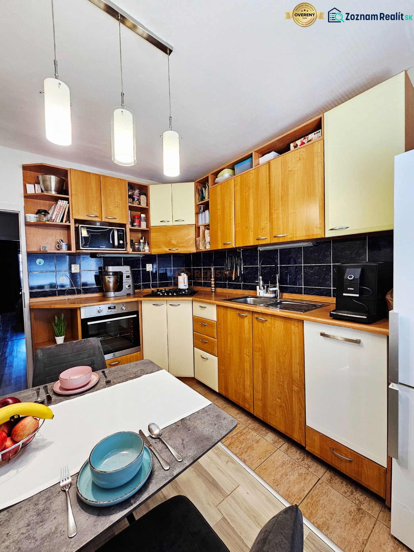 A kitchen with a wooden decor floor and a dining table in a three-room apartment.