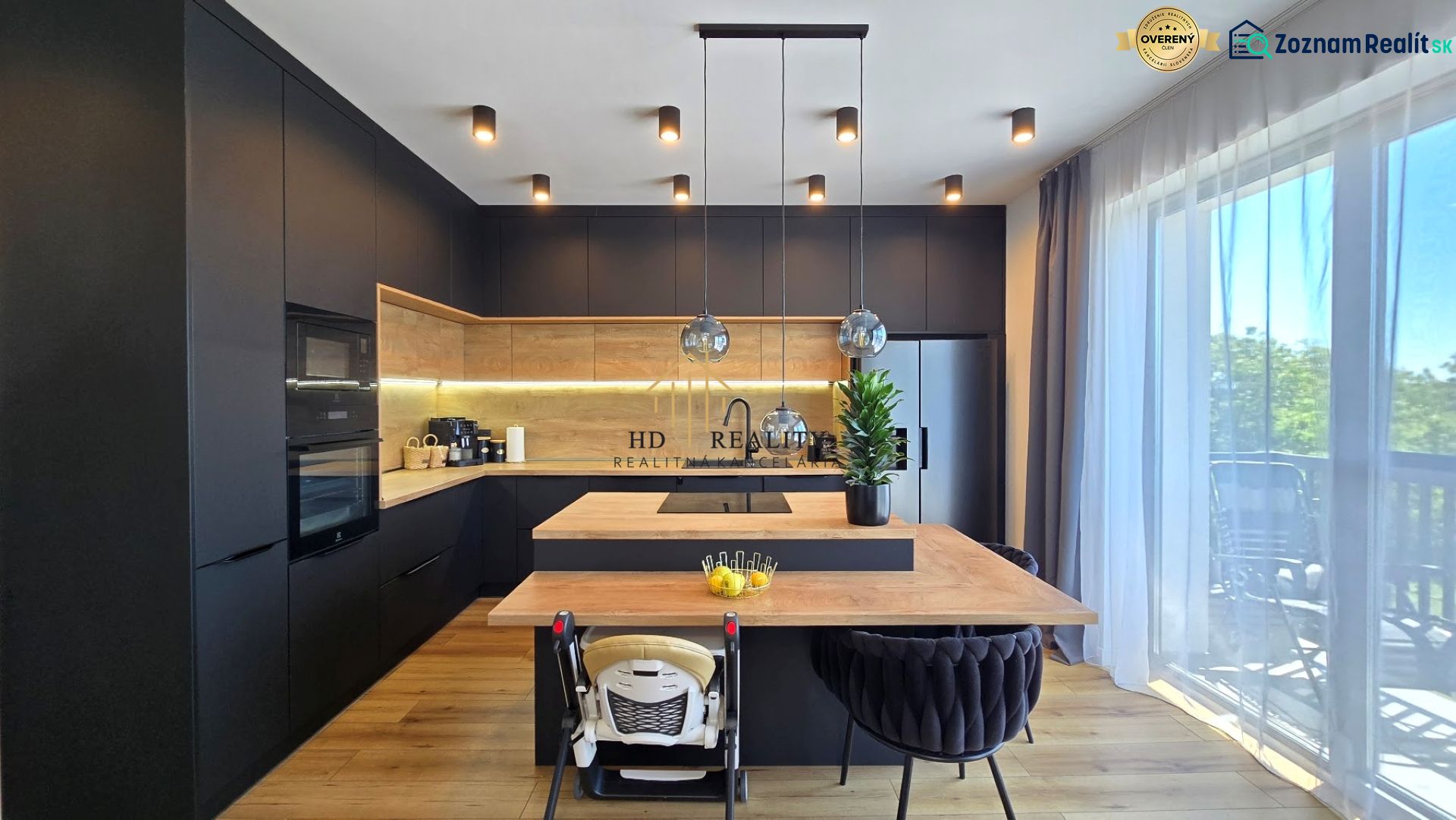 Black kitchen in a 3-room apartment with a light floor and a large window.