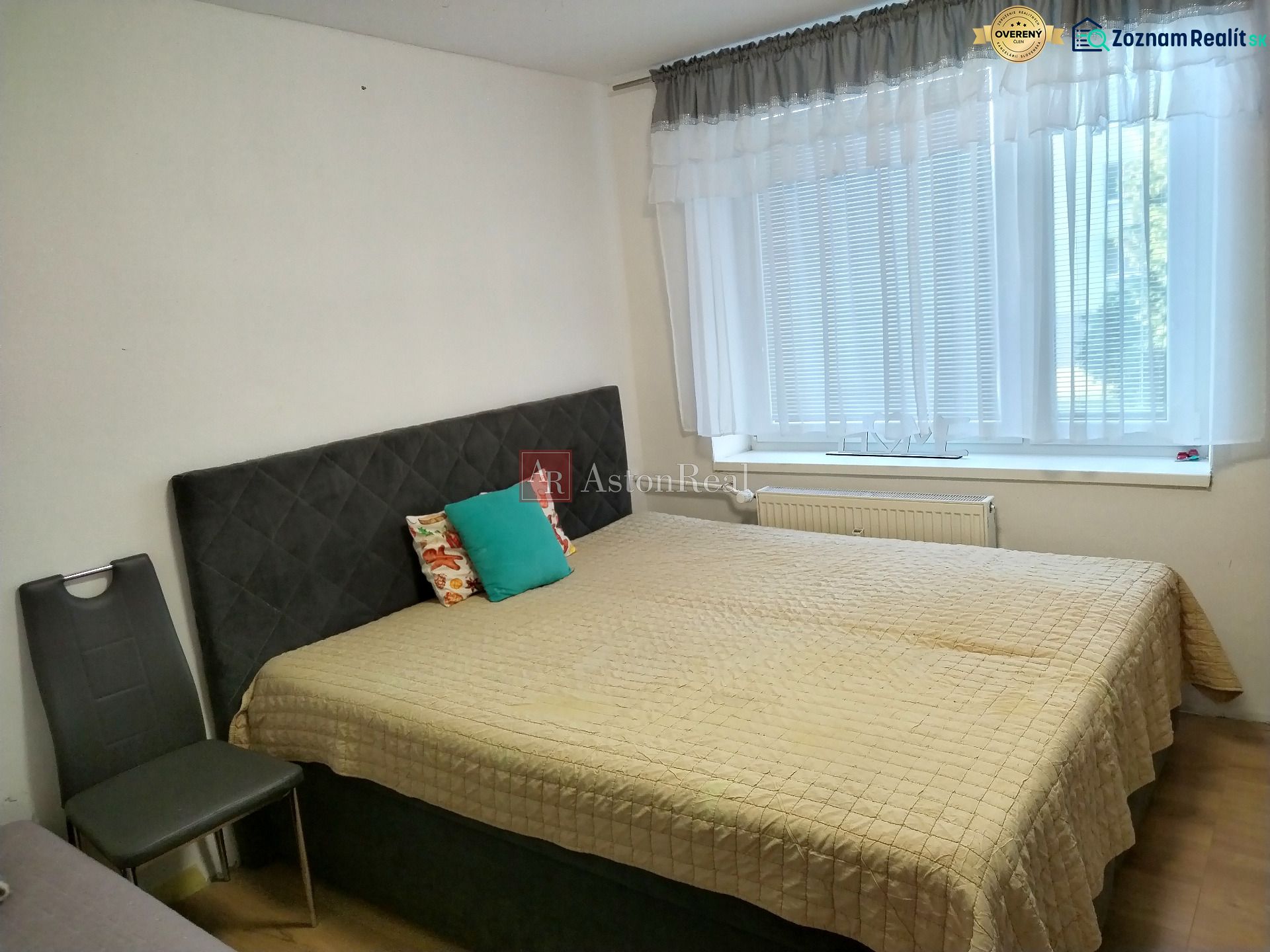 Bedroom in a 2-room apartment with a comfortable bed and a large window.