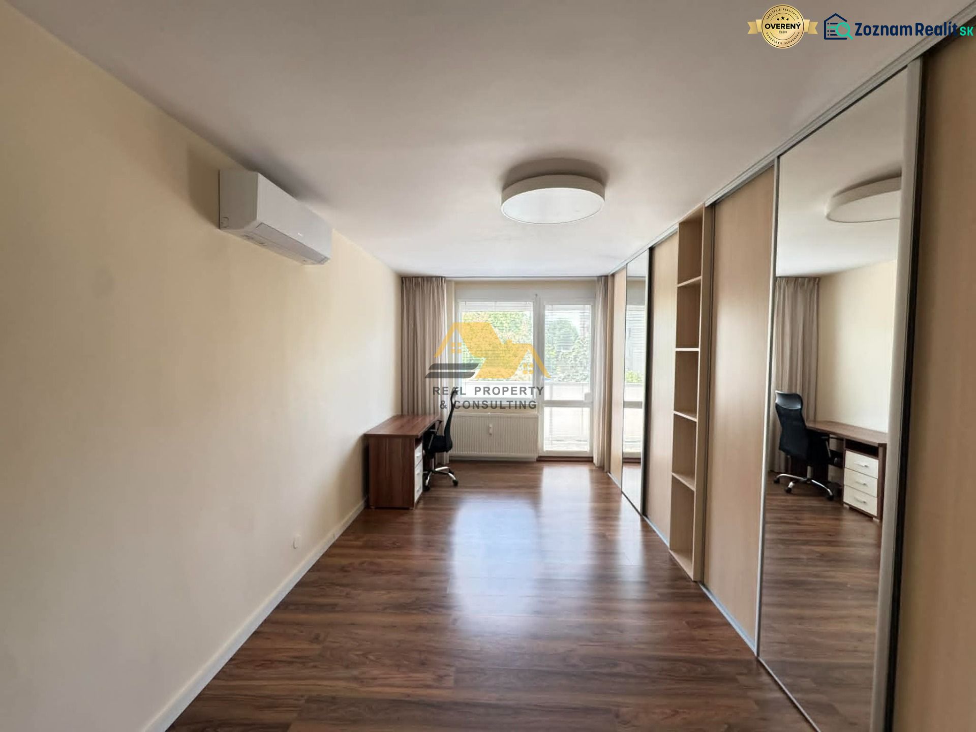 Interior of a 3-room apartment with a wooden decor floor and a built-in wardrobe.