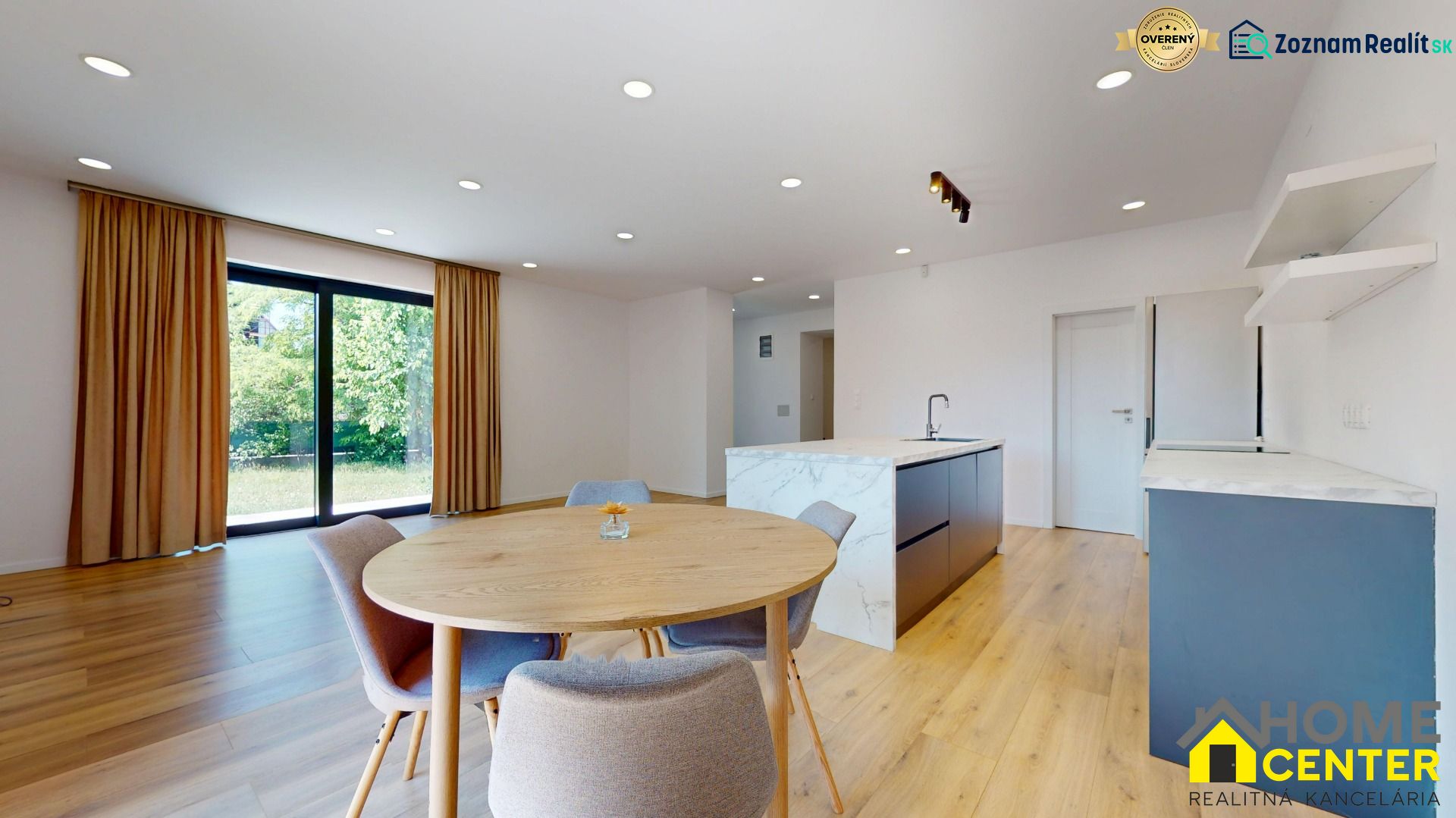 A kitchen with an island, a round table, and a wooden decor floor in a family house.