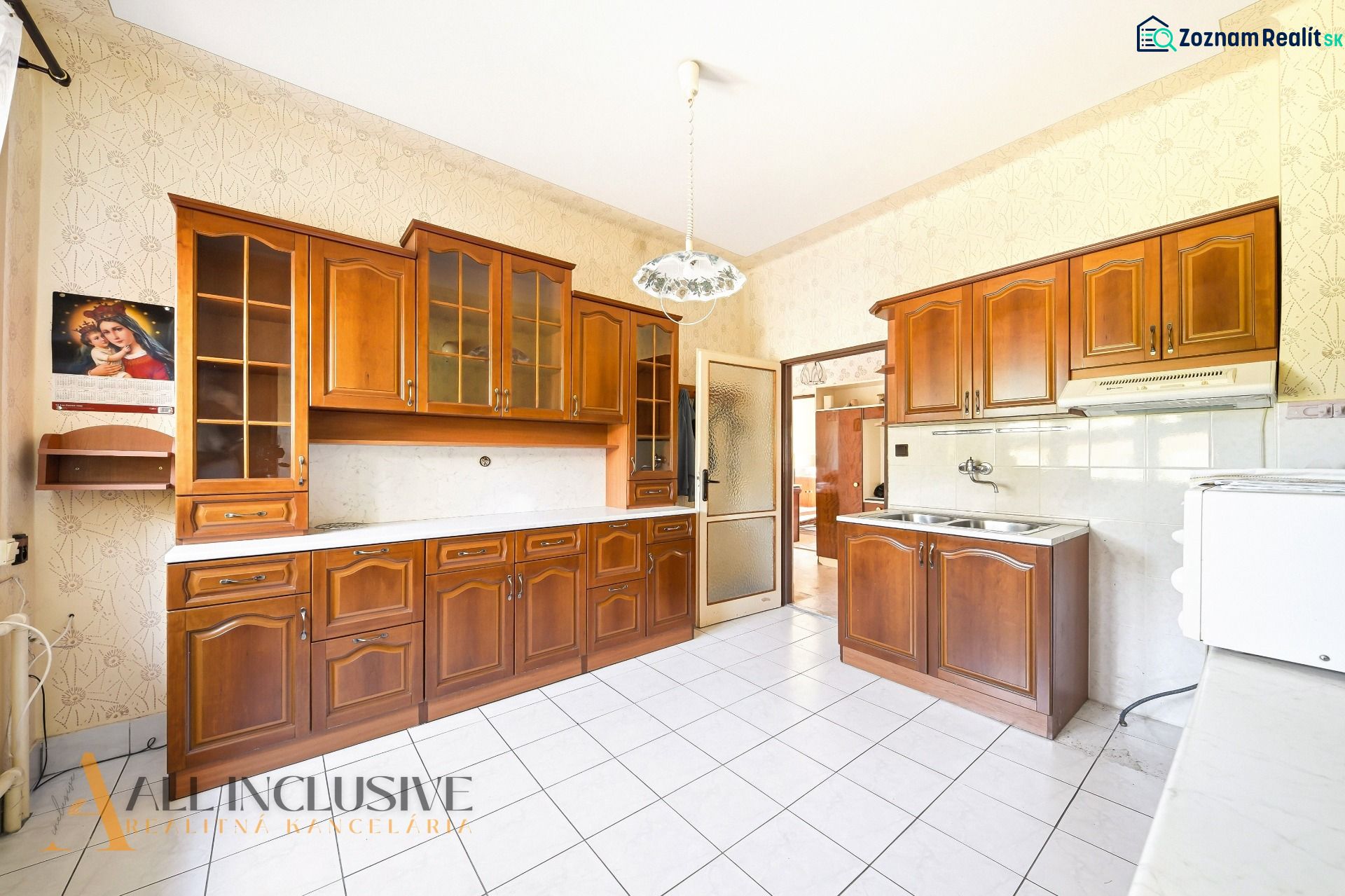 A kitchen in a family house with wooden cabinets and white tiles.