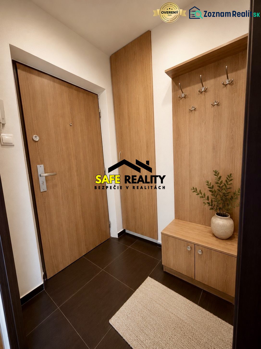 A hallway of a studio apartment with wooden decor, a built-in wardrobe, and a practical coat rack.