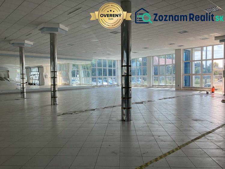 Spacious commercial spaces with glass walls and columns, drawing attention to the interior.