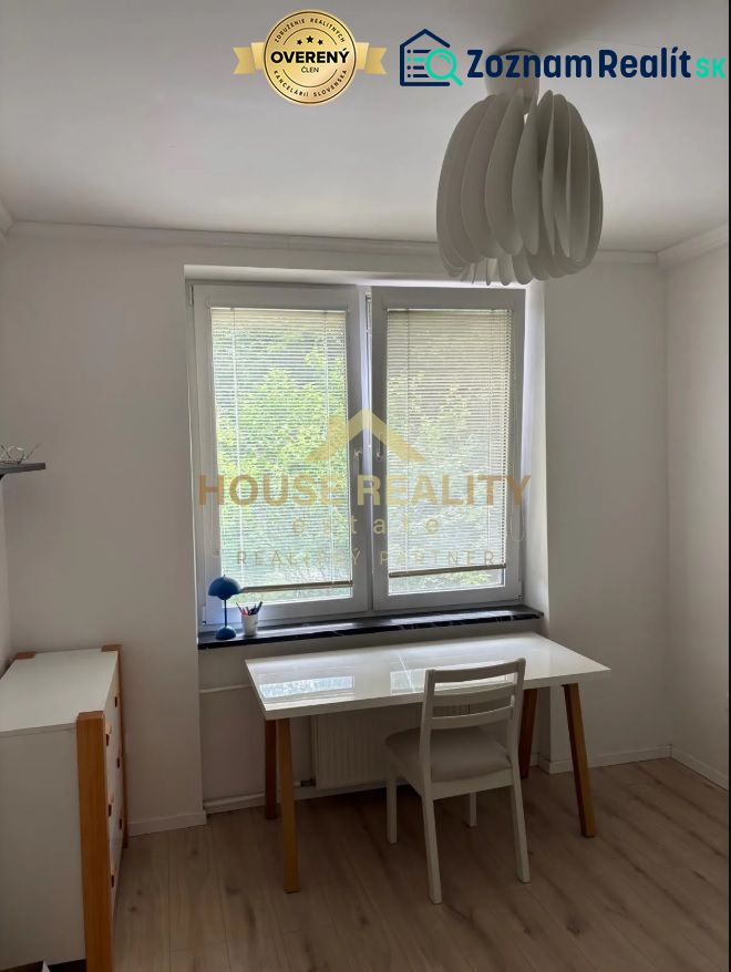 White desk, chair, and wooden decor flooring in a 3-room apartment.