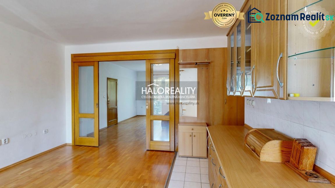 A kitchen unit in a 3-room apartment with sliding doors and a wooden decor floor.