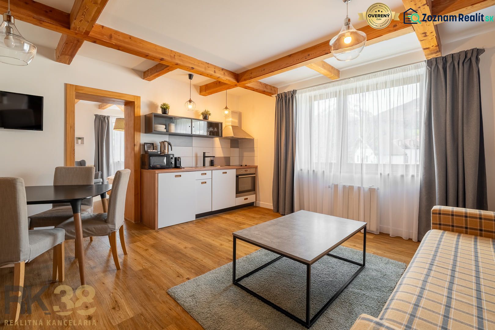 Living room with kitchen, wooden decor flooring, dining area and sofa.