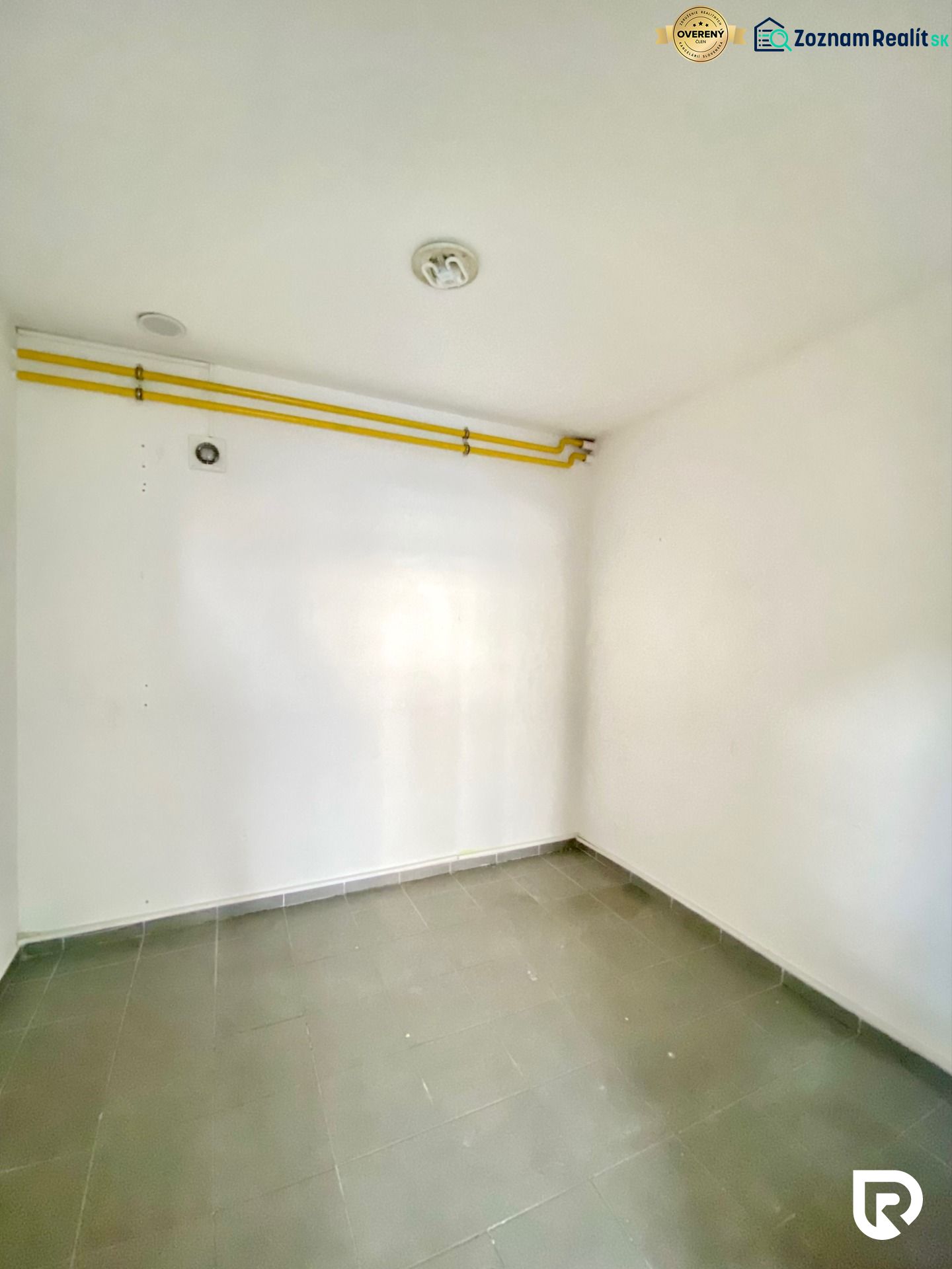 Empty room with tiles, piping, on Zlatovská Street suitable for commercial premises.