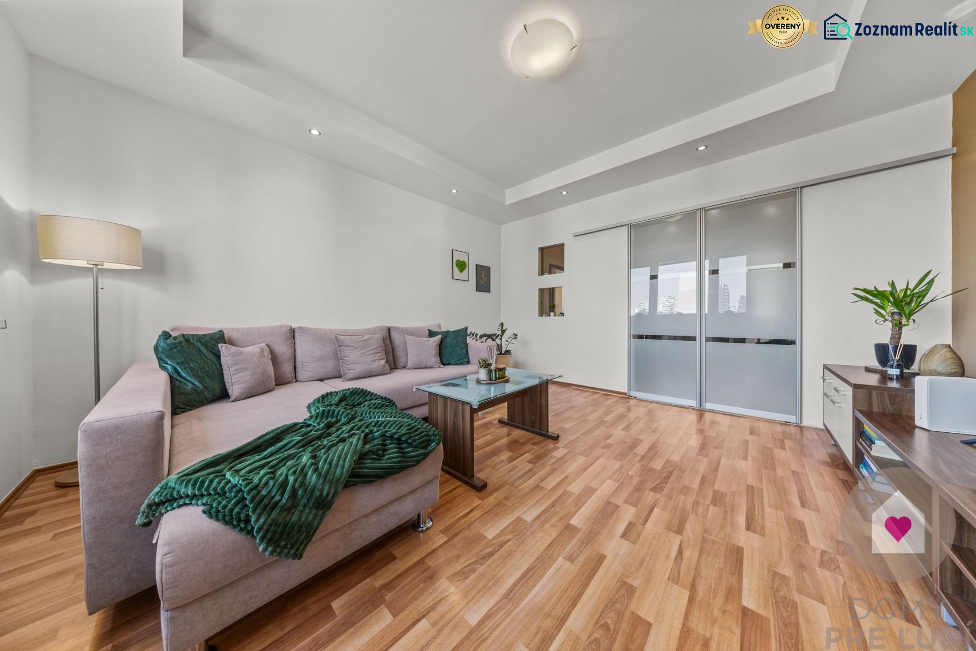 Living room with a gray sofa, wood-patterned flooring in a 4-room apartment.