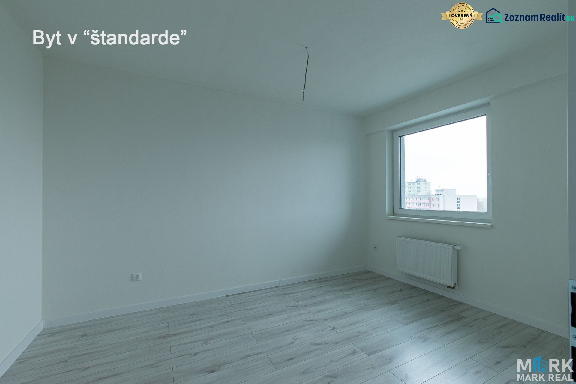 A room with a wooden floor decor, a window, and a radiator in a 2-room apartment.