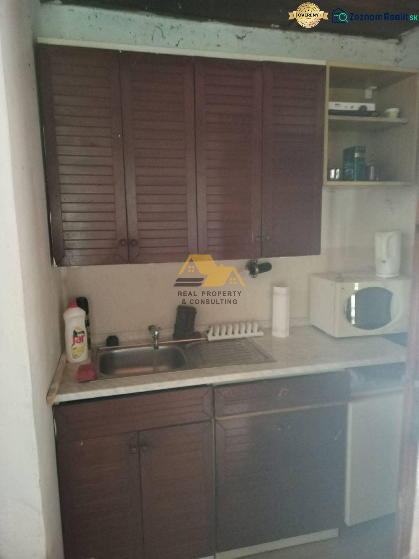 A kitchenette in a cabin with wooden cabinets and a sink, compact layout.