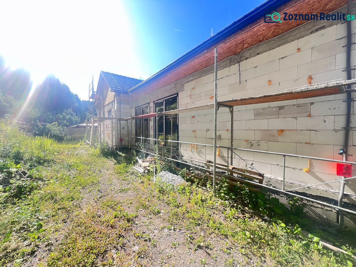 Construction of a family house in Badín, Banská Bystrica district, with green surroundings and scaffolding.