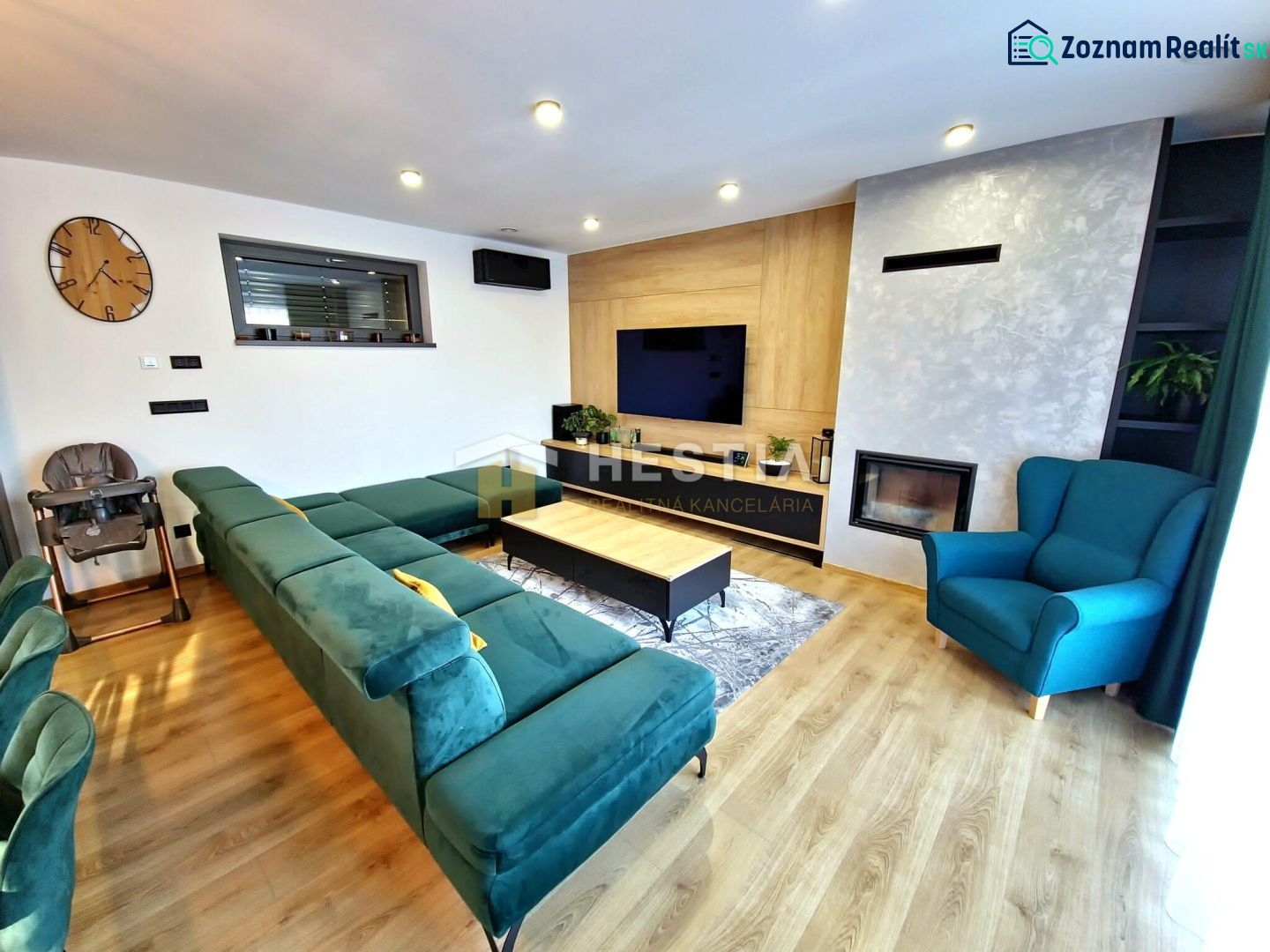 Living room in a family house with a comfortable green sofa and a fireplace, floor with wooden decor.