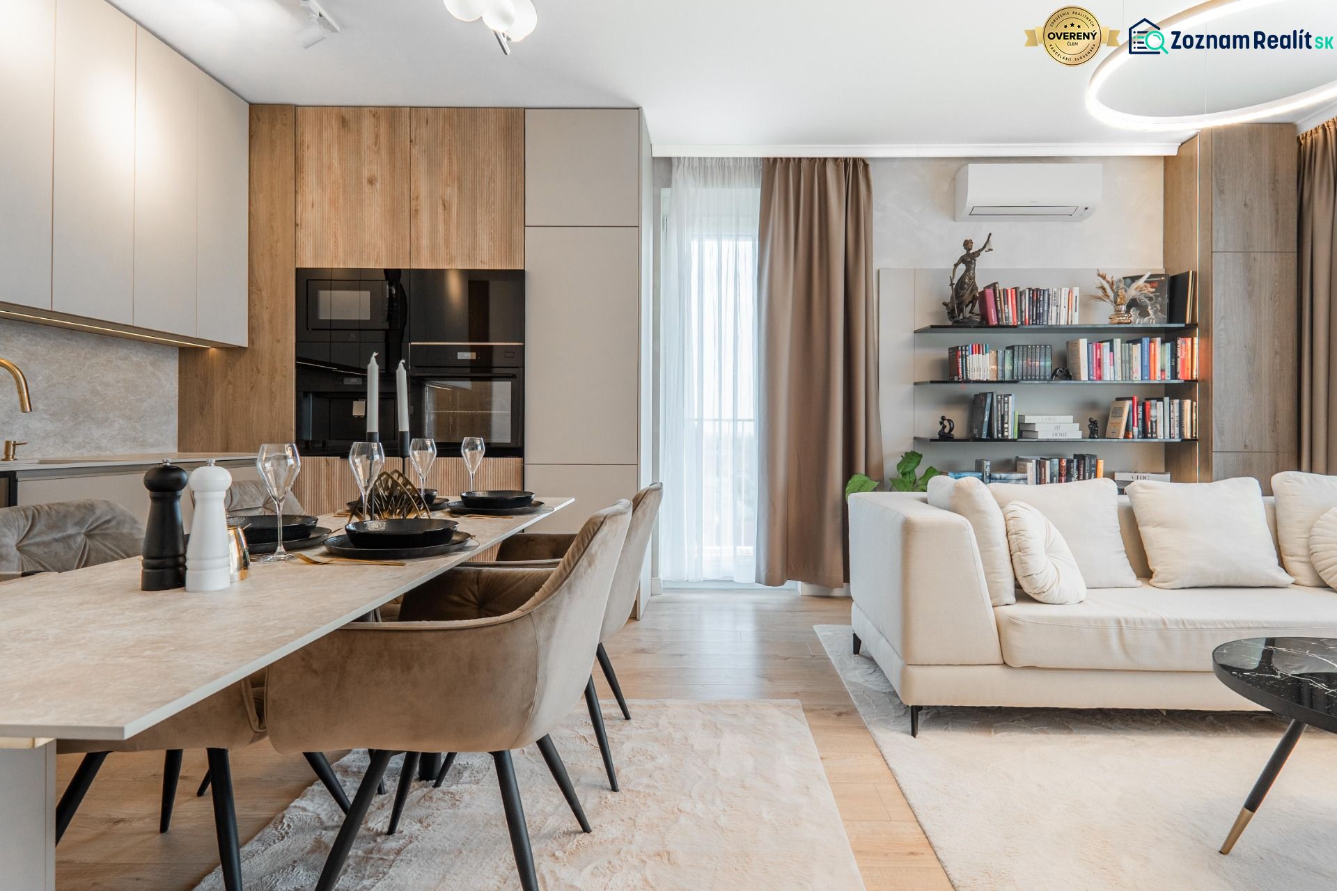 Open-plan three-room apartment with a kitchen, dining table, and comfortable living area.