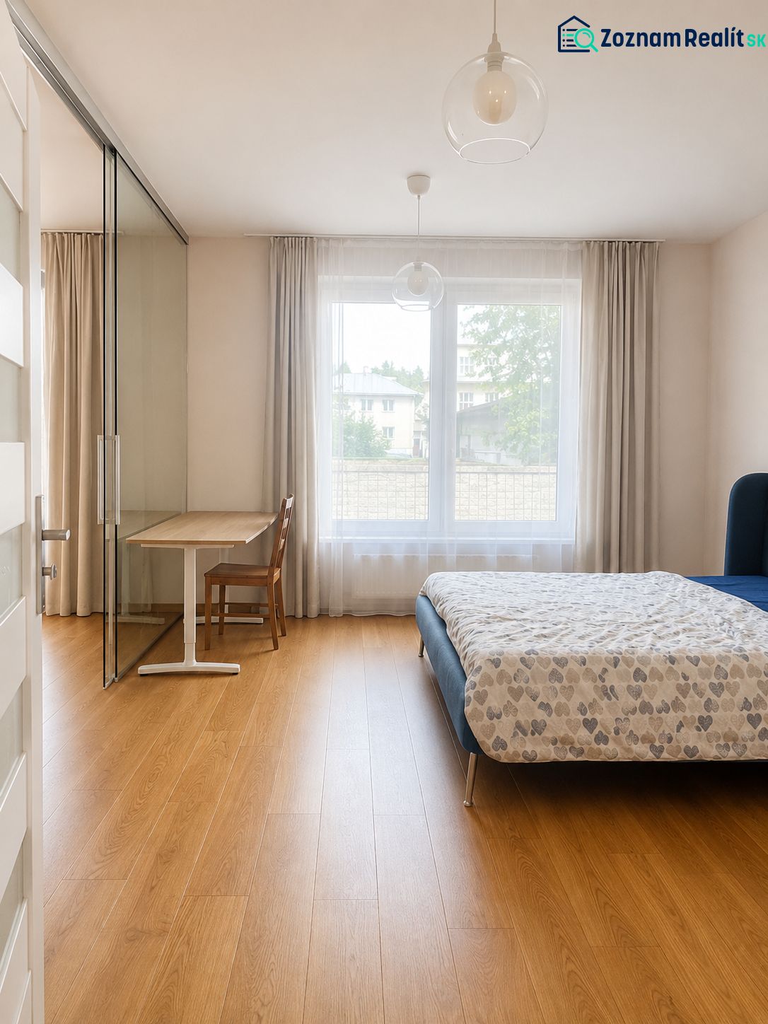 Bedroom in a 2-room apartment with a bed, table, curtains, and a floor with a wooden decor.