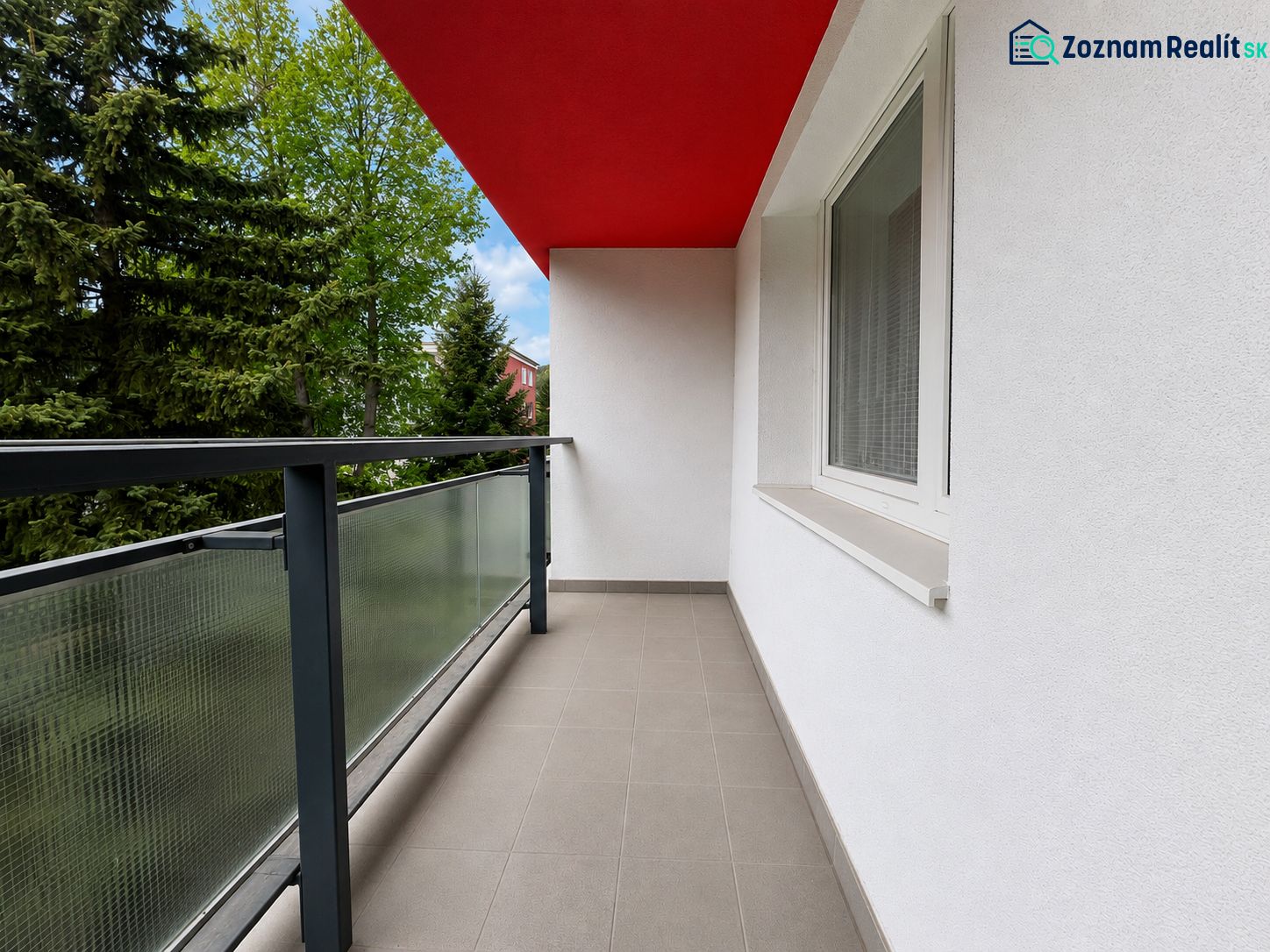 Balcony from a 2-room apartment with a red ceiling and railing with glass.