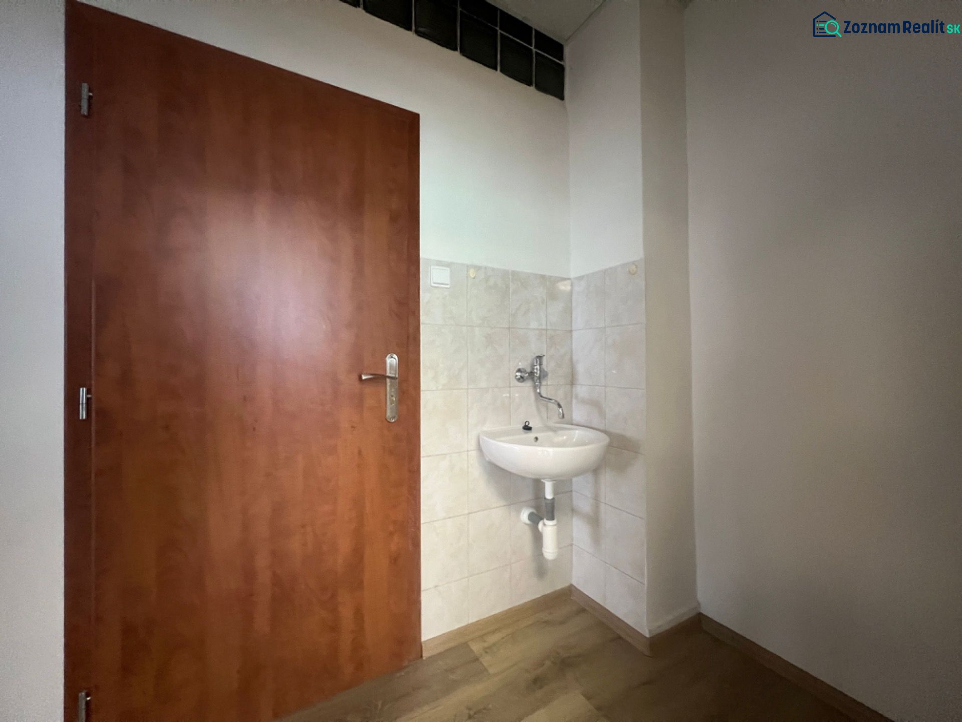 Offices with a sink, doors, and a floor with a wood design.