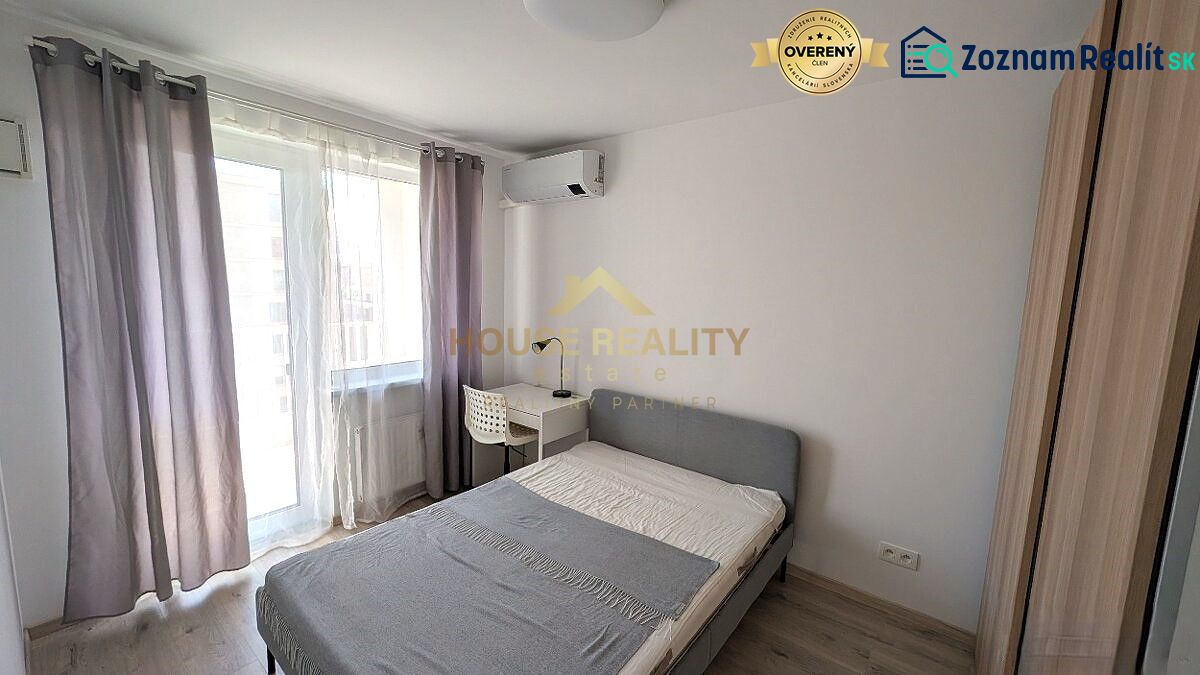 A stylish bedroom with a bed, a table, and a wooden decor floor in a two-room apartment.