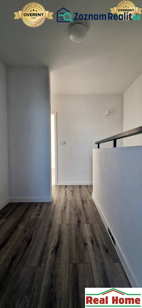 A hallway in a family house with a wooden decor floor and white walls.
