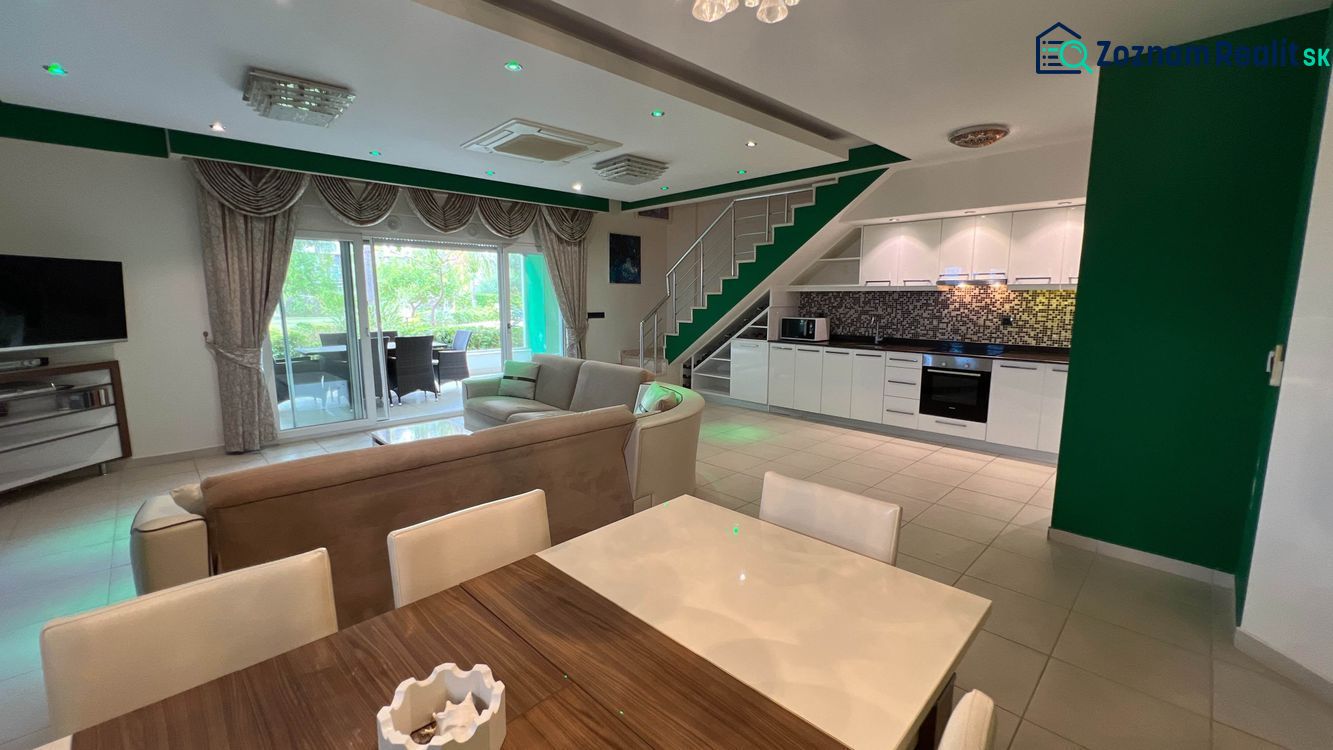 Spacious living area with kitchen and dining room, unique properties, comfortable seating.
