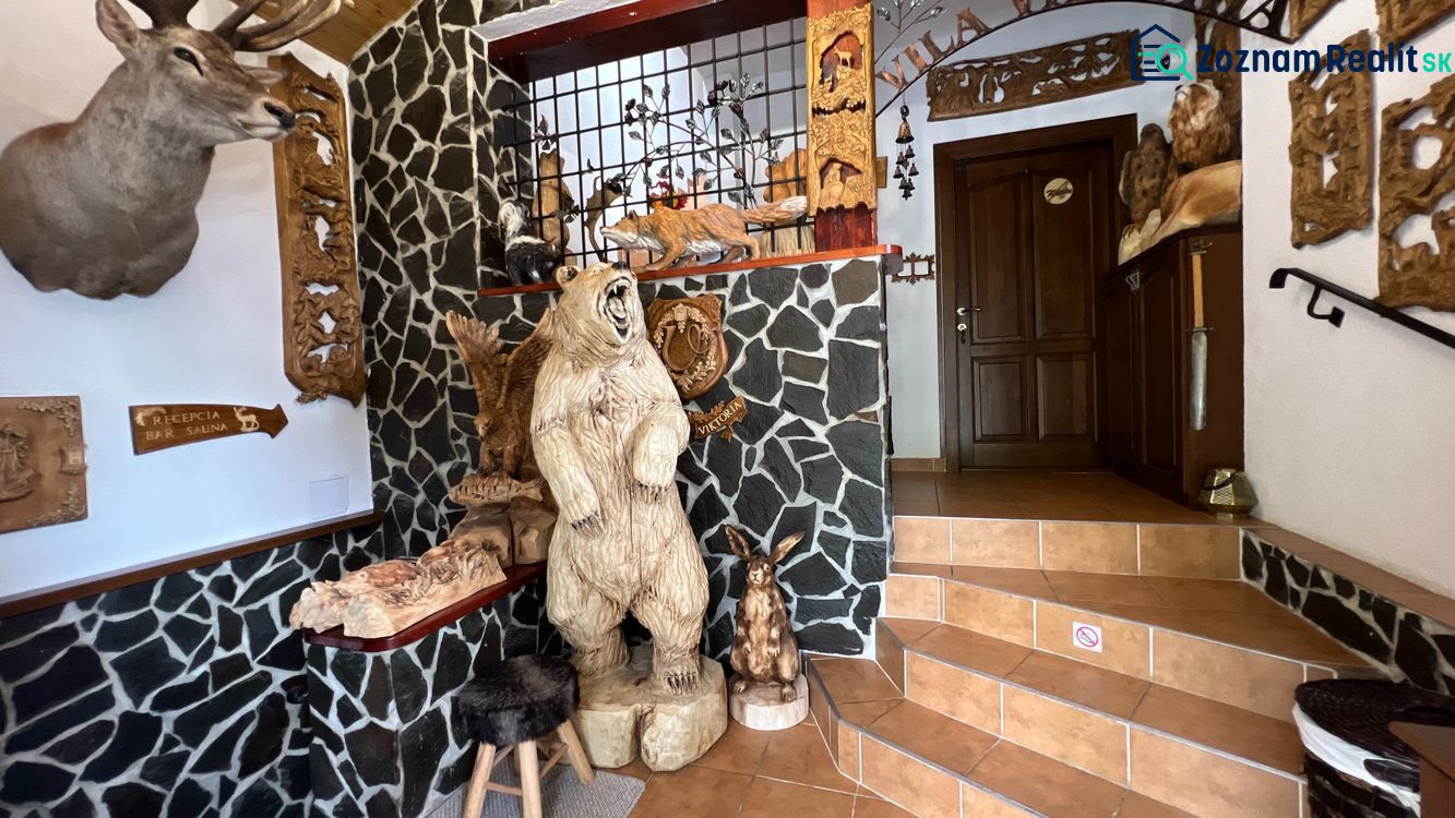 Interior of a villa with wooden animal sculptures and stone walls.