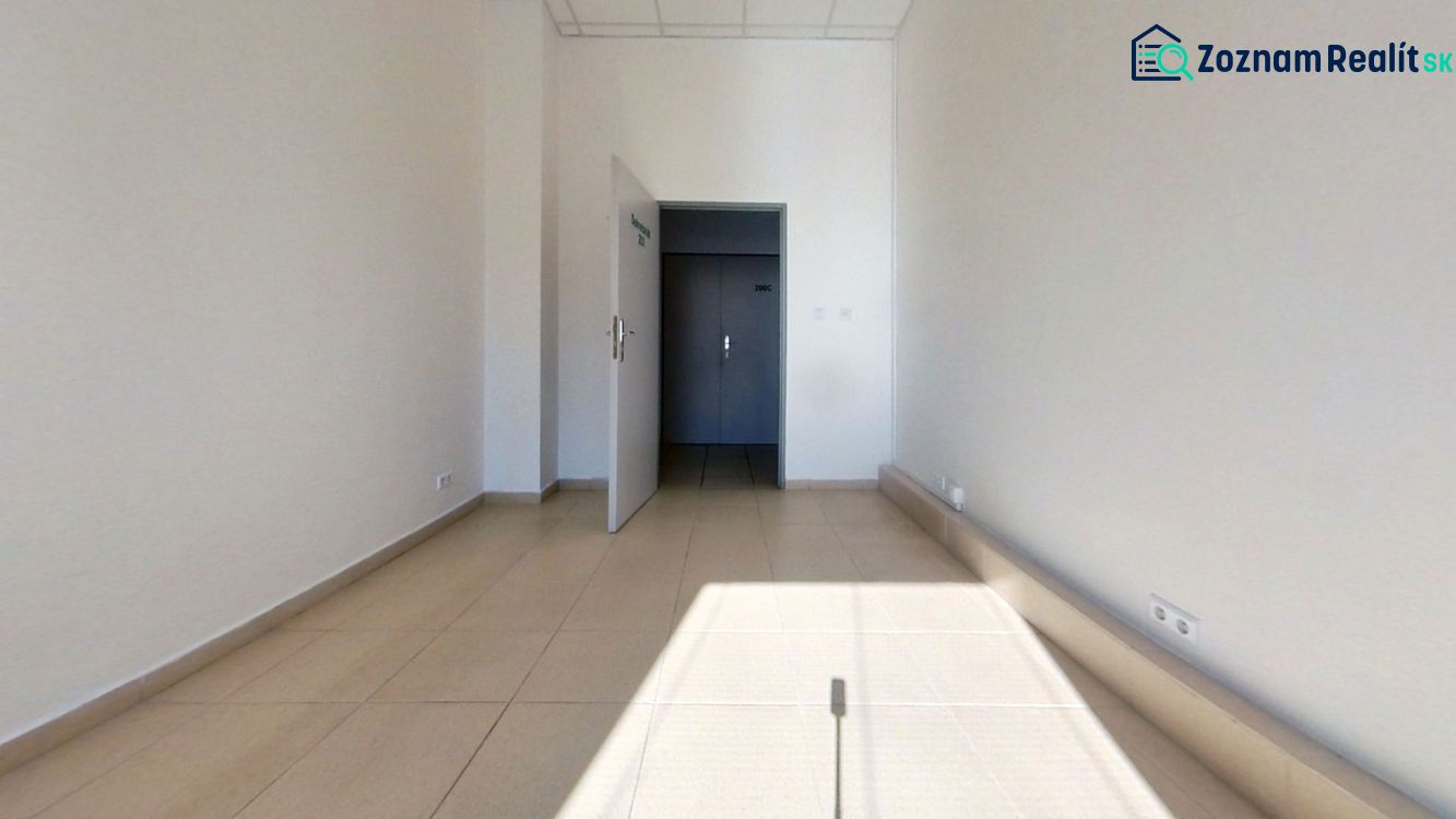 The interior of an office with white walls and light ceramic floor tiles.