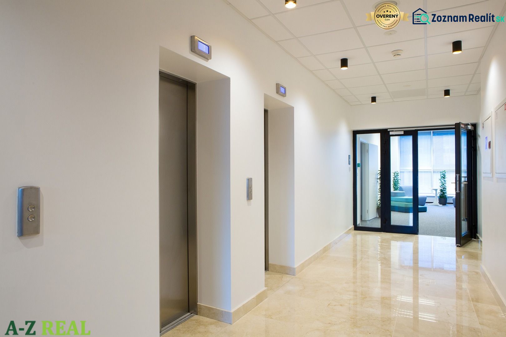 In the offices, you can see a hallway with elevators and light marble flooring.