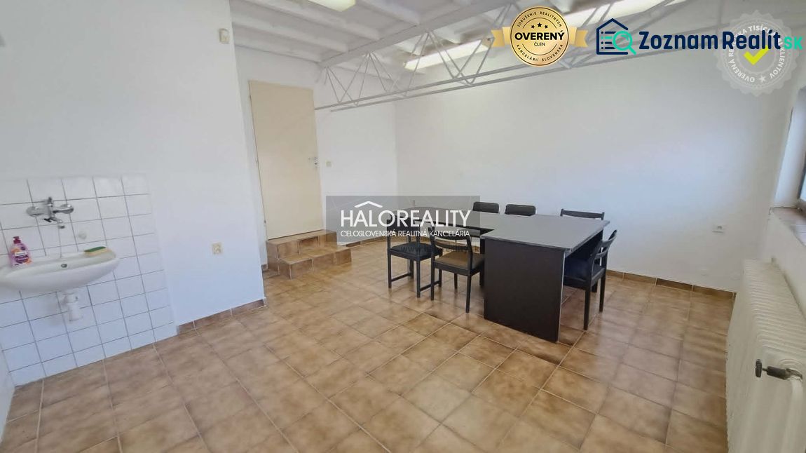 Offices with tiles and a sink. A table and chairs in a spacious room.