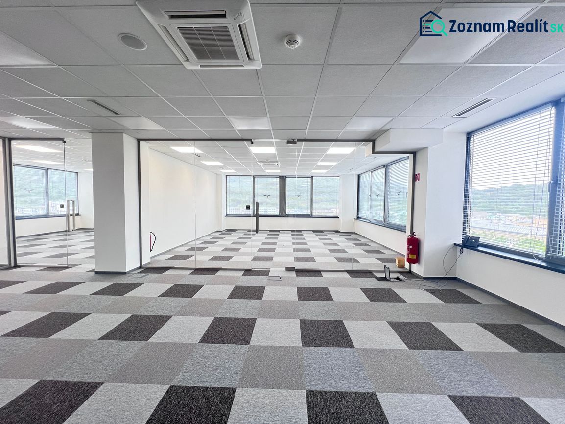 Empty office with carpet tiles and large windows.