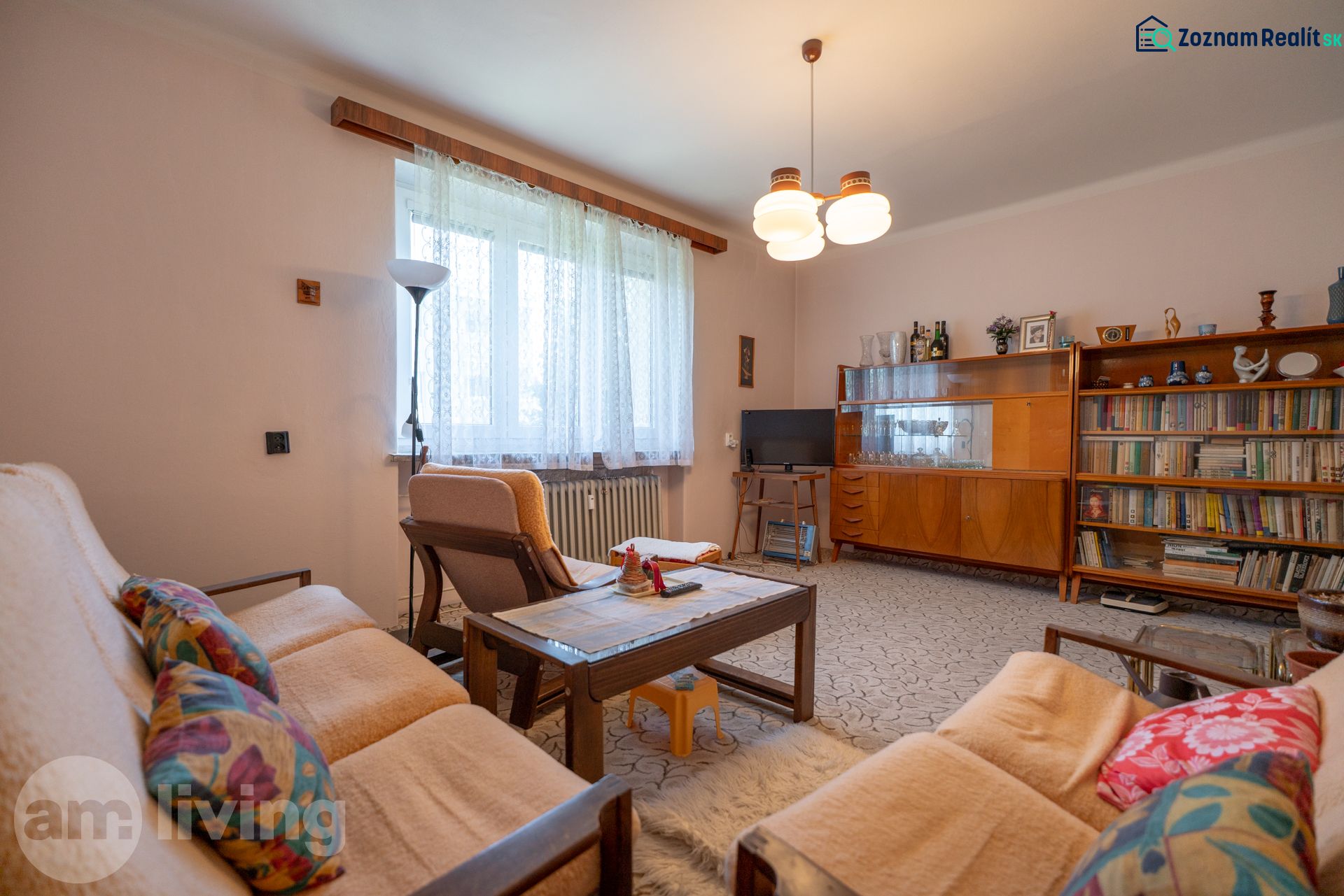 Living room in a 3-room apartment with retro furniture, a sofa, and a bookshelf.