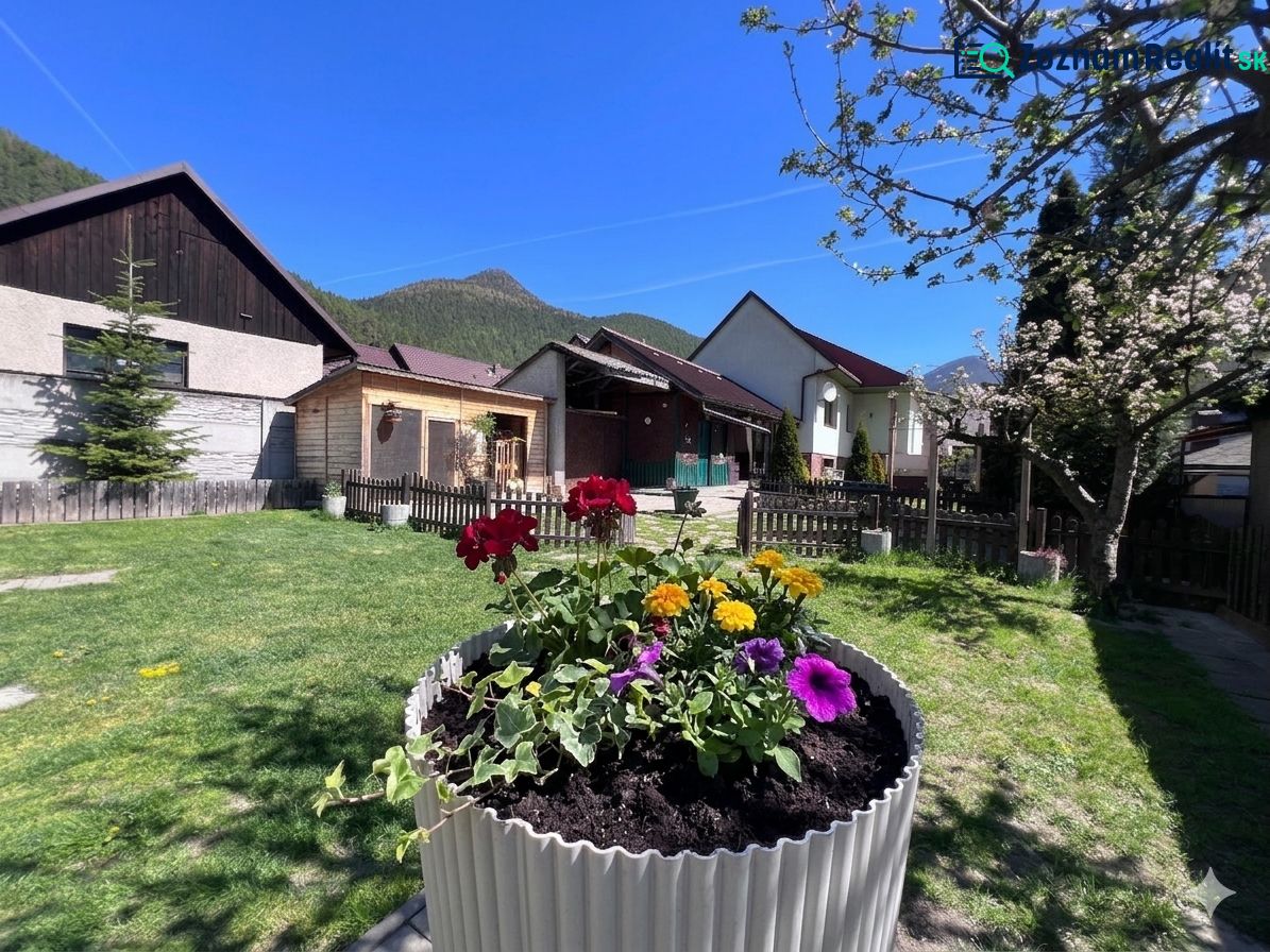 A family house in Švošov with colorful flowers and a green lawn in the garden.